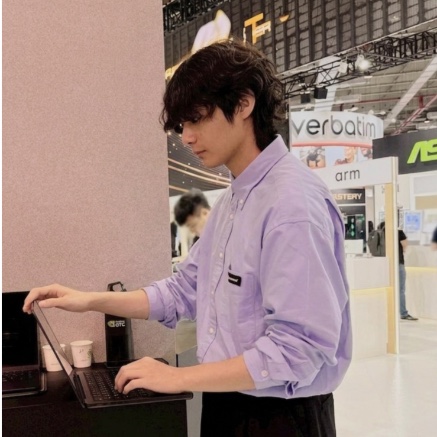 Archong Liu at a laptop on a trade-show floor